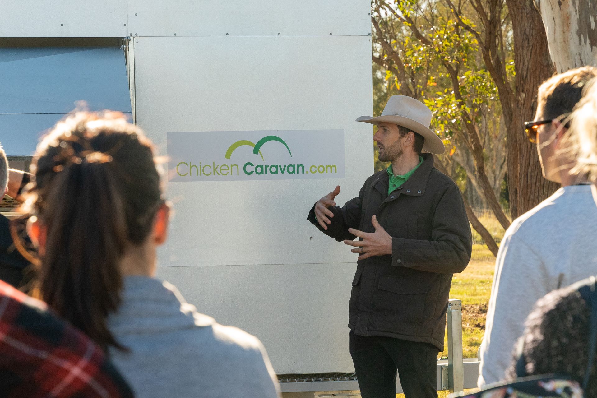 Daniel presenting beside a Chicken Caravan 450 at farm open day
